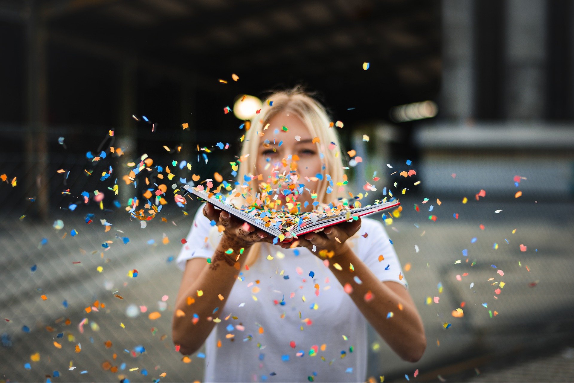 woman blowing a bunch of confetti from the pages of a book symbolizes the notion of flexibility of viewpoint - no one point is the 'truth'